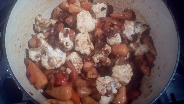 After about five minutes the carrots will have started to soften. Stir well and add the cauliflower. Add the chili powder and ground spices sprinkled over the cauliflower, stir and replace the lid.